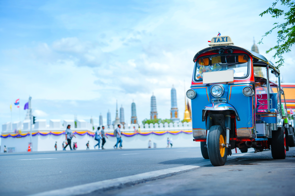View of a street in Bangkok with a tuk tuk. There are many things to do in Thailand with a toddler.