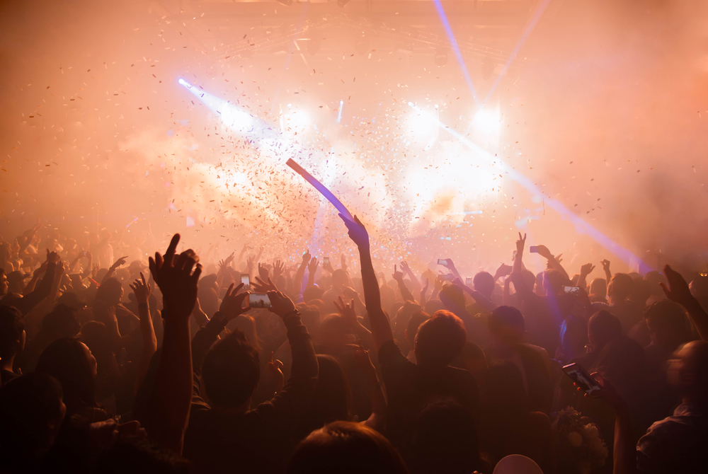 A vibrant club crowd on a laser-lit dance floor showing RCA Bangkok nightlife at peak hour.